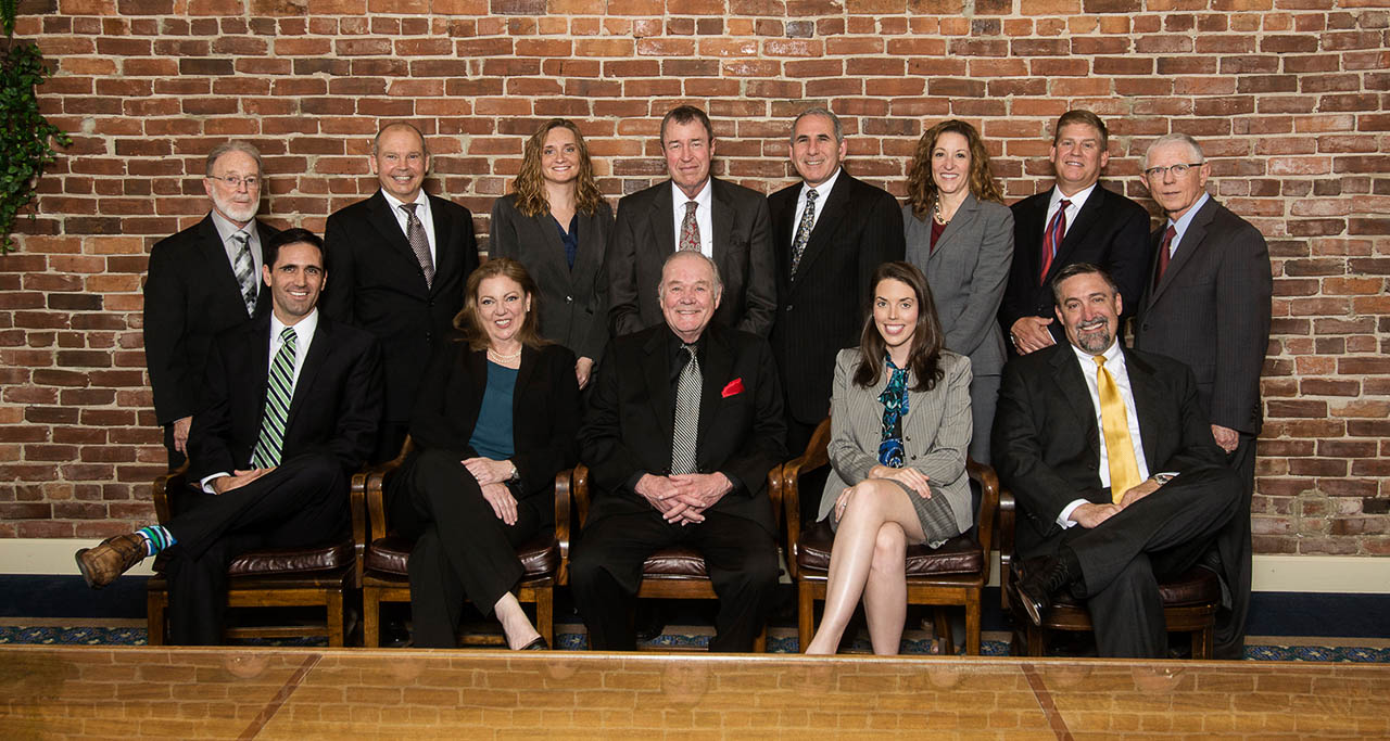 Group photo of attorneys for their website photographed against antique brick wall in their office