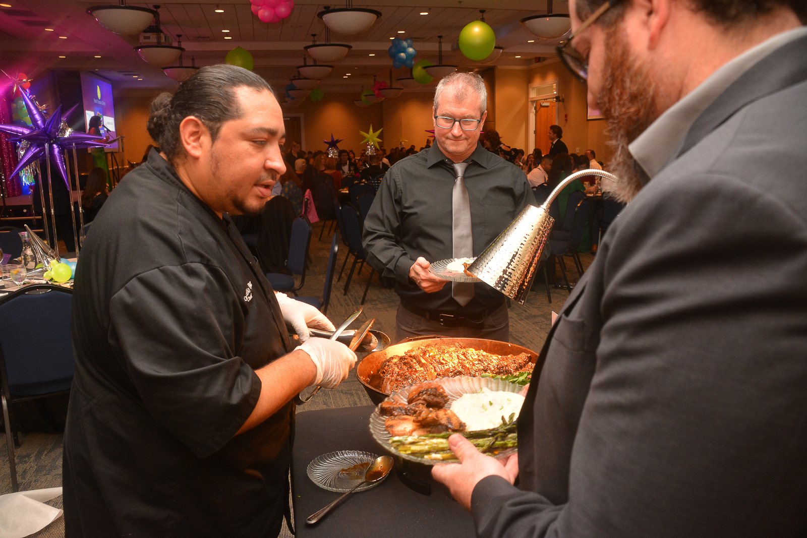 Chef carving meat for attendees at the Xtraordinary Joy event in Gainesville, Florida.