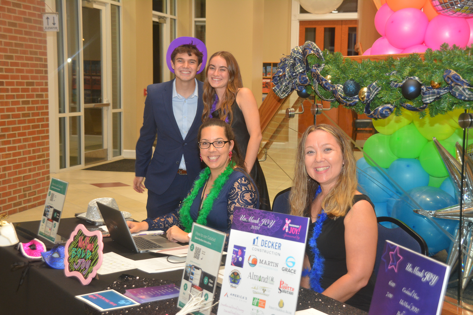 Four attendees gathered at the check-in table during the Xtraordinary Joy event in Gainesville, Florida. Photo by Mike Shea Photography.